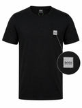 A black short-sleeve crewneck t-shirt by Hugo Boss, featuring a small silver-toned square logo patch on the left chest. A circular inset on the right provides a close-up view of the logo patch.