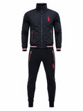 A men's two-piece tracksuit set in black, featuring a zip-up jacket with red and white striped ribbed cuffs and hem, and matching joggers with red zipper accents and a red embroidered polo player logo.