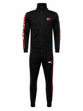 A black Tommy Hilfiger track jacket and matching track pants set, featuring red and white side stripes, a red and white vertical logo on the sleeve, and a Tommy Hilfiger flag logo on the chest and thigh.
