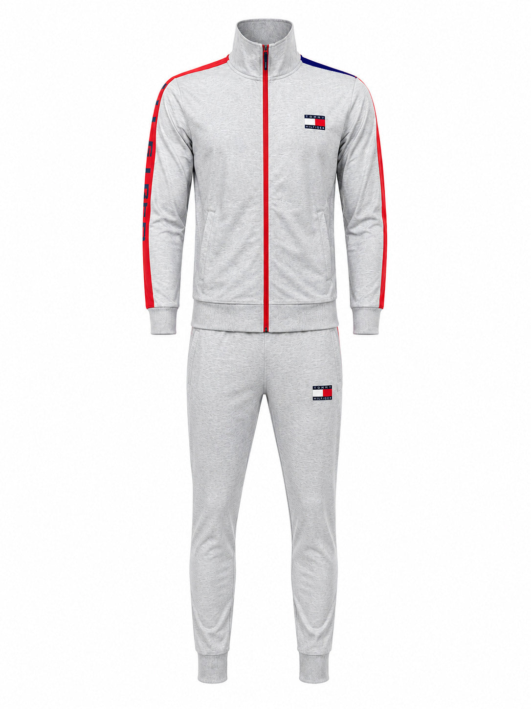 A light gray heather two-piece tracksuit featuring a zip-up jacket and matching jogger pants. The jacket has red and blue stripe accents on the shoulders and sleeves, a red center zipper, and a small Tommy Hilfiger flag logo on the left chest and right thigh.