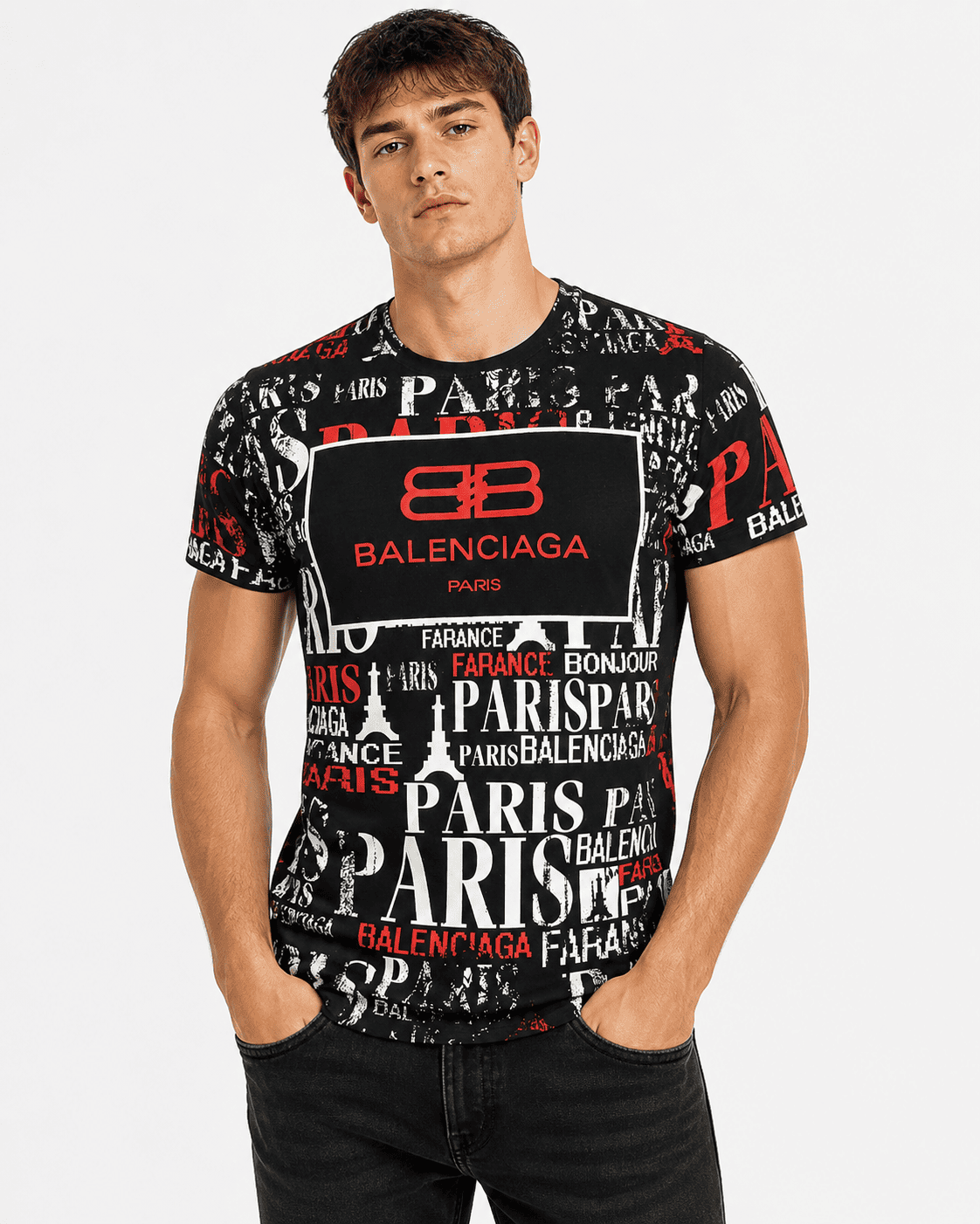 A male model wearing a Balenciaga Paris short-sleeve t-shirt with a black, white, and red Paris-themed graphic print, paired with black jeans, against a light gray studio background.